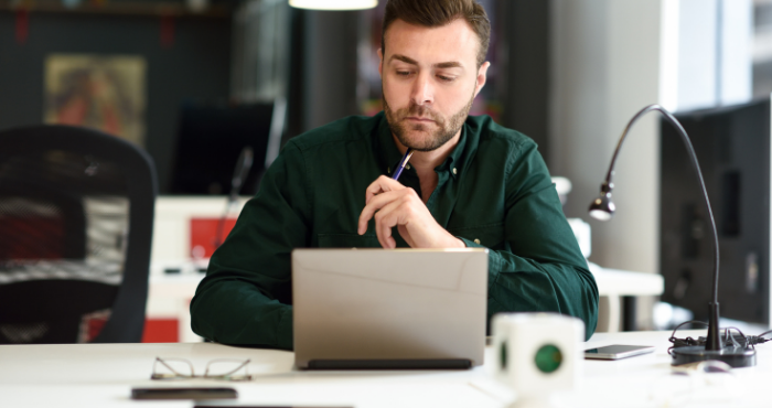 young-male-student-working-at-laptop-at-desk