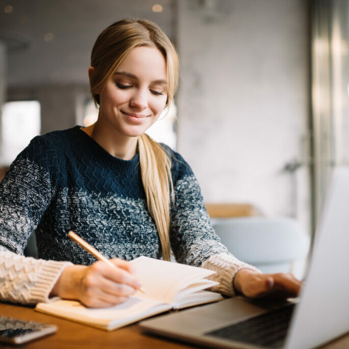 Young attractive university student using laptop computer, study