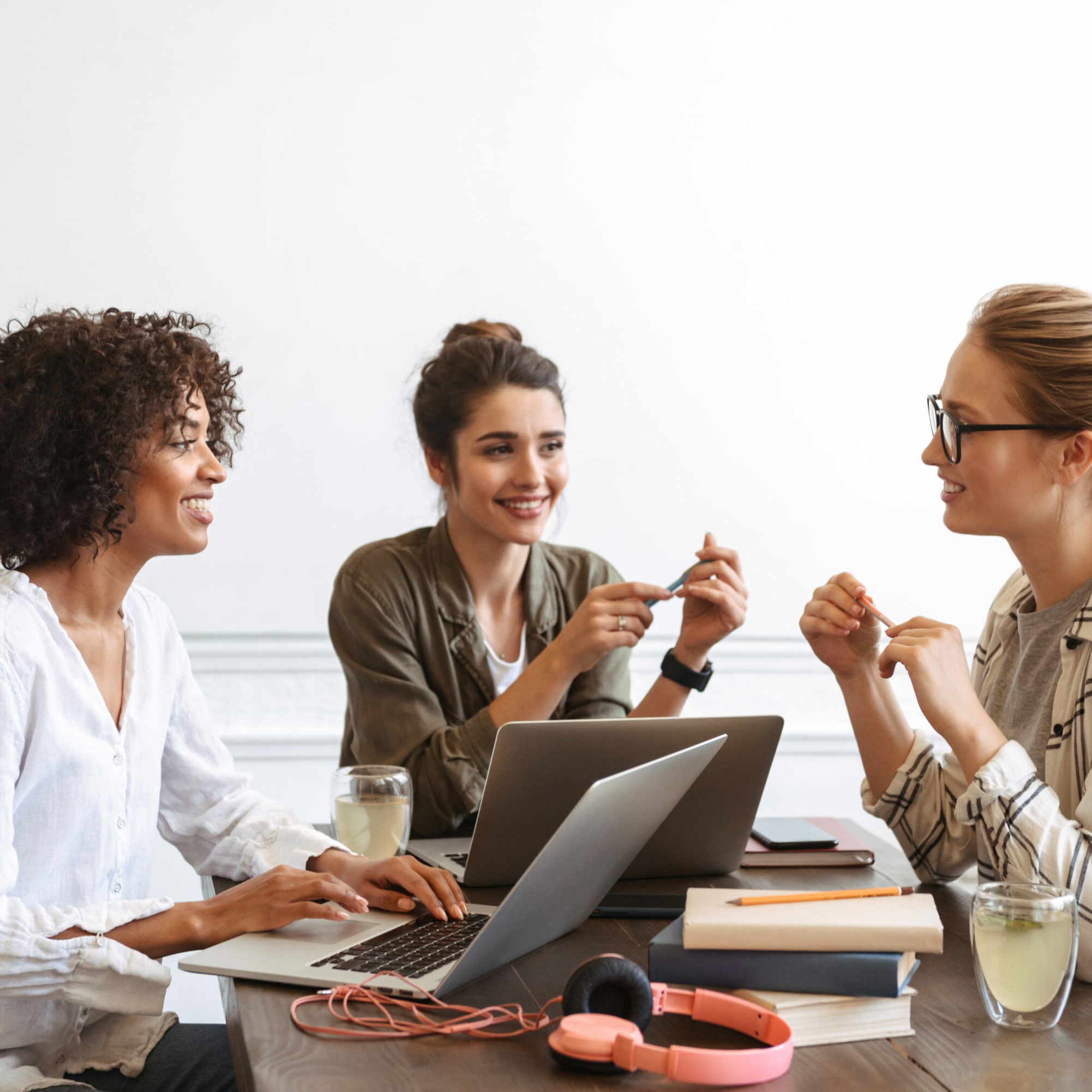 Group of multiethnic cheerful young women studying together at the coffee shop