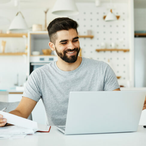 Portrait of a young man with laptop at home