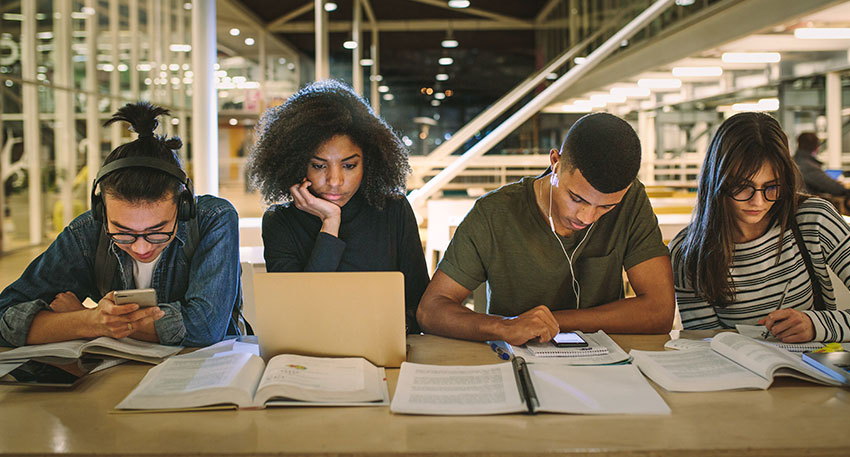 Four law students learn about the MPRE while doing research in the law library