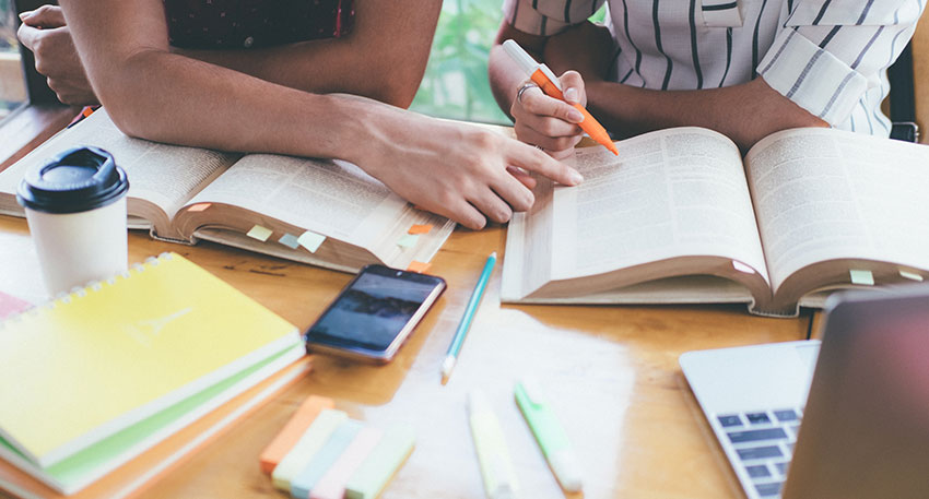 Two barbri students take notes and creating study guides together