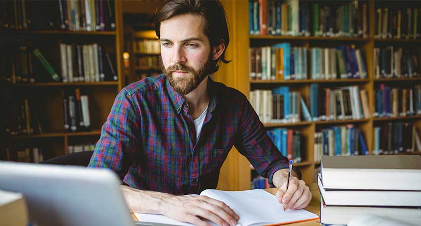 A male law student works on his law school case briefs in the law library