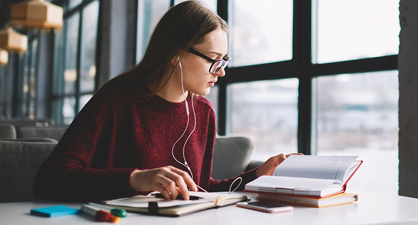 A female barbri student sits in the library and takes notes